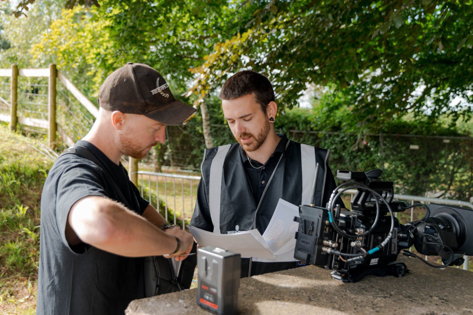 two men reading papework next to camera