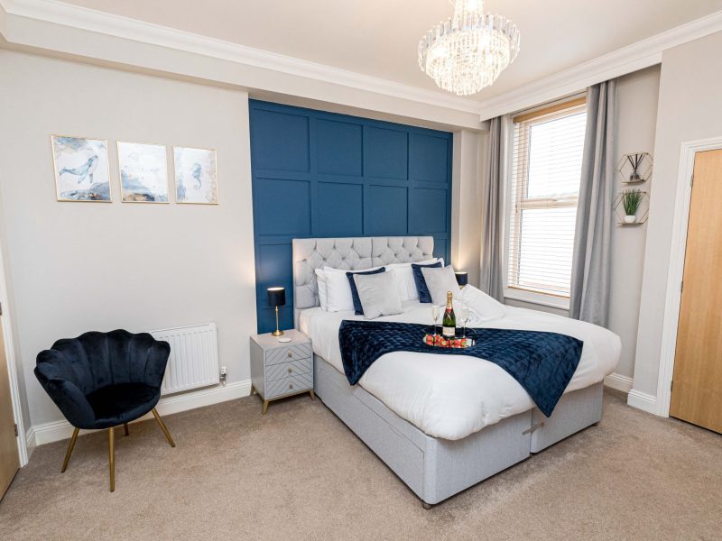 Luxury spacious bedroom with champagne on bed