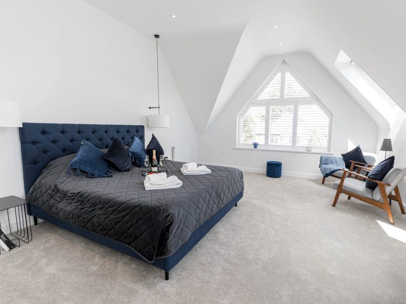 Spacious white bedroom with sloped ceiling