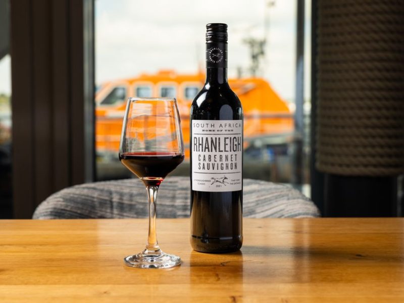 Wine bottle with glass of wine next to it