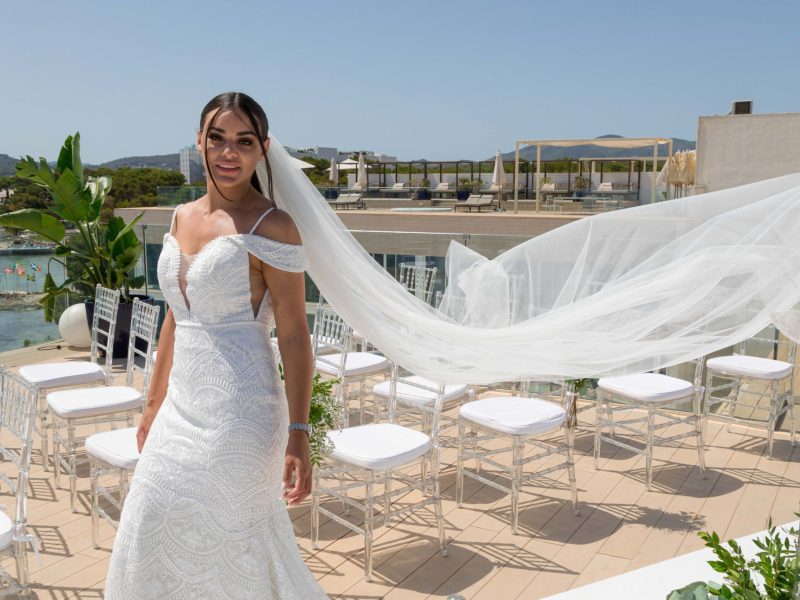 Bride at wedding with vail trailing behind