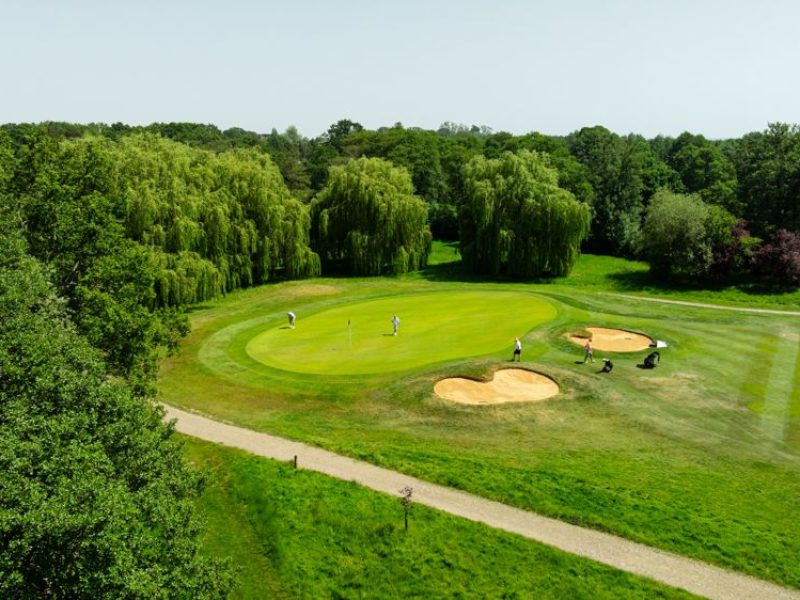 Drone picture of a golf course green surrounded by bunkers